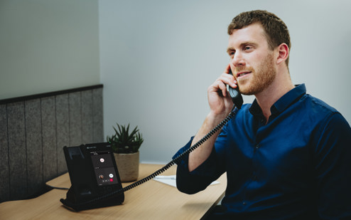 A Man Using an AudioCodes C470HD IP Phone 3