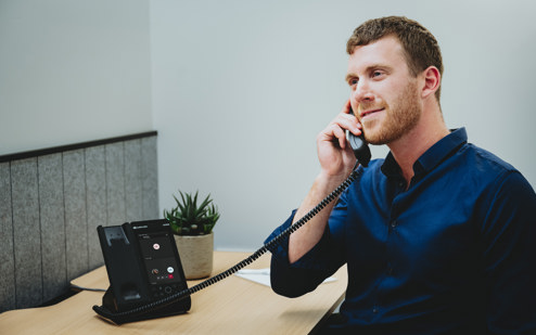 A Man Using an AudioCodes C470HD IP Phone 2