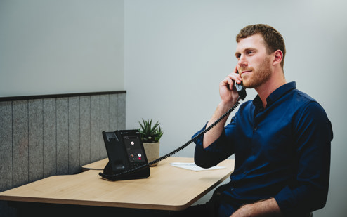 A Man Using an AudioCodes C470HD IP Phone