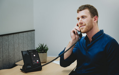 A Man Using an AudioCodes C470HD IP Phone 4